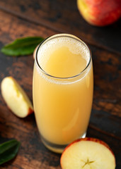 Apple juice in glass on rustic wooden table
