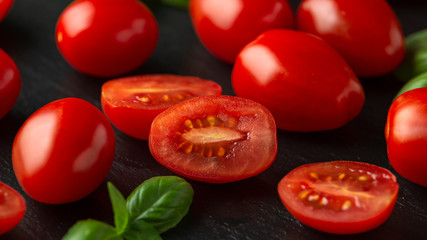 Red Baby Plum Tomatoes on black rustic background
