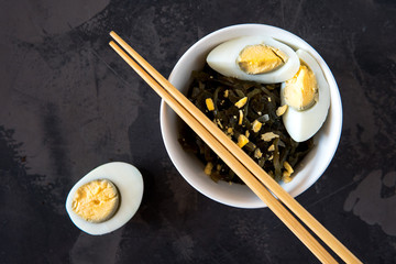 Far Eastern salad - sea kale with egg in a white cup.
