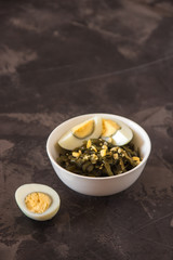 Far Eastern salad - sea kale with egg in a white cup.