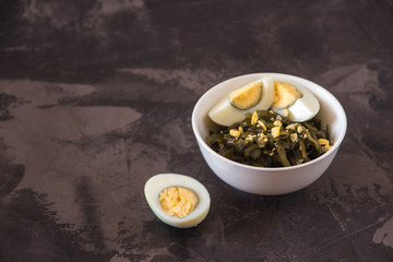 Far Eastern salad - sea kale with egg in a white cup.