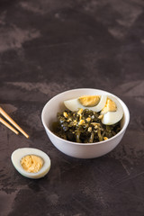 Far Eastern salad - sea kale with egg in a white cup.