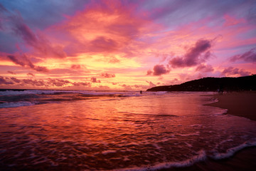 Beautiful sunset on ocean beach. Sky is reflecting at water.