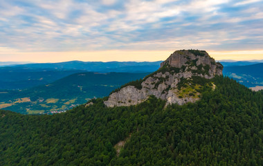 Aerial view to Mala Fatra mountains in Slovakia. Sunrise above mountain peaks and hills in far. Beautiful nature, vibrant colors. Famous tourist destination for hiking and trekking. Cloudy weather.