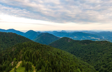 Aerial view to Mala Fatra mountains in Slovakia. Sunrise above mountain peaks and hills in far. Beautiful nature, vibrant colors. Famous tourist destination for hiking and trekking. Cloudy weather.