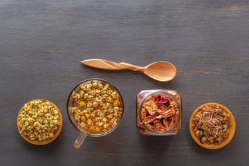 Herbal tea with pharmaceutical chamomile, dry chrysanthemum, a jar of dry rose petals and hunters...