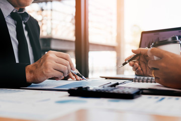 Two businessmen discussion analysis sharing calculations about the company budget and financial planning together on desk at the office room.