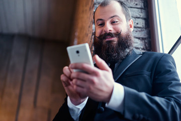 Trend and technology. Young bearded man using smartphone.