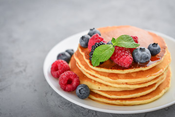 Pancakes with fresh berries and maple syrup