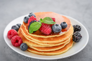 Pancakes with fresh berries and maple syrup