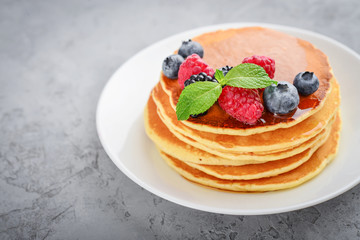 Pancakes with fresh berries and maple syrup