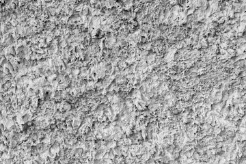 Gray texture of uneven plaster on the wall of the house.