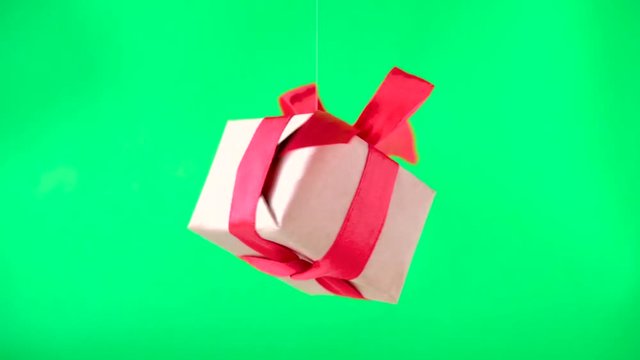 Gift box with red ribbon spinning on green screen. 360 degree rotation. seamless loop. zero gravity. levitation. chroma key. Concept sales, discount price, christmas holidays and shopping.