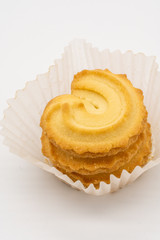 Stack of homemade cookie in white paper packaging on white