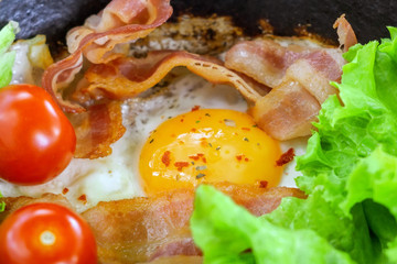 Sunny Side Up Eggs with crispy fried bacon, arugula and tomatoes