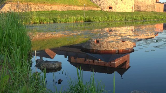 Reflection of the ancient fortress of Hameenlinna close-up, Sunny summer morning. Finland 