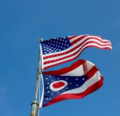 The two flags on the flagpole waving in the wind.