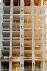Modern building under construction detail, concrete frame, indow openings and scaffolding