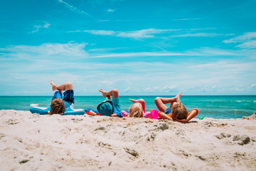 father with son and daughters relax on beach