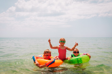 happy kids-boy and girls-enjoy swimming at beach