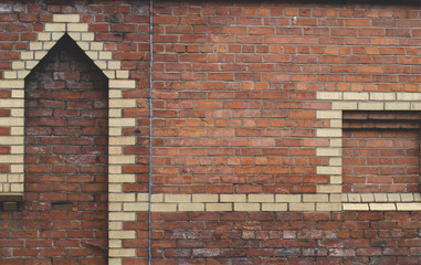 Red brick stone wall with yellow bricks to create tower shapes