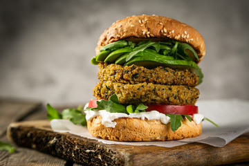Vegan zucchini burger and ingredients on rustic wood background, copy space