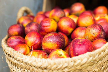 ripe nectarines in wicker baskets on counter