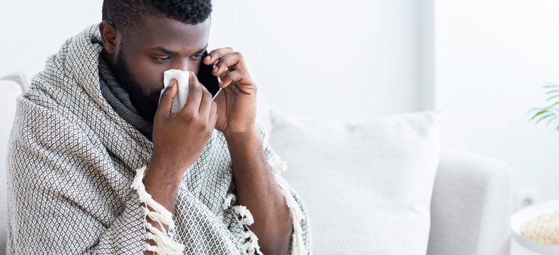 Sick black man calling on phone. to doctor