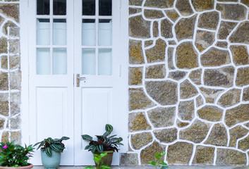 The white doors and the background of the stone walls have contrasting white lines.