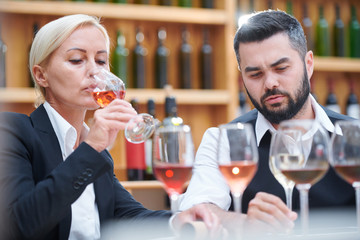 Male and female cavists working with samples of new sorts of wine