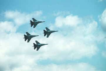 Group of four military aircraft of fighters, jet airplane in the sky make maneuvers