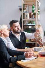 Two colleagues consulting about characteristics of one of wine samples