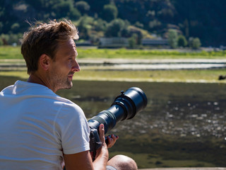 White male photographer enjoying shooting in the nature during summer