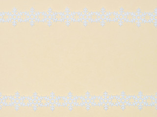 White laces snowflake on beige background. Christmas and New year concept