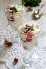 Eton mess, traditional English dessert with gooseberry, whipped cream and meringue on a light background. Rustic style.