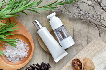 Cosmetic bottle containers packaging with green herbal leaves, Blank label for organic branding mock-up, Natural skincare beauty product concept.