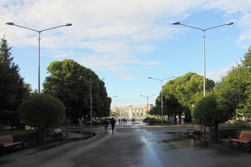 Fototapeta na wymiar Gorky Park Moscow, view of the alley with street lights and the main entrance on a Sunny summer day after the rain