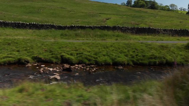 A Dolly style shot (actually shot with a drone) of a country wall and stream. The shot was taken at Barbon Beck Valley, Carnforth. Travelling right to left.
