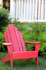 This red wooden chair is on the front lawn.