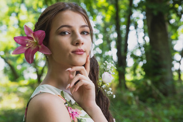 beautiful girl with lilies in her hair, flowers in the luxurious dark hair of a young lady