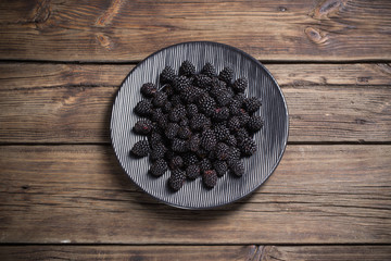 blackberry on plate on wooden background