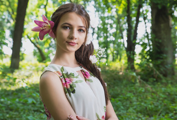 Fototapeta premium beautiful girl with lilies in her hair, flowers in the luxurious dark hair of a young lady