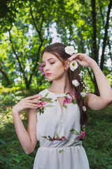 beautiful girl with lilies in her hair, flowers in the luxurious dark hair of a young lady