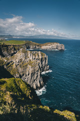 Lookout from Ponta do Cintrao at cliffs and coastline in sunny weather with beautiful cloudy blue sky, Sao Miguel Island, Azores