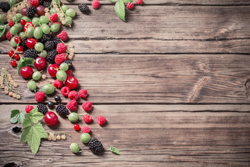 different berries on old wooden background