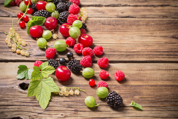 different berries on old wooden background