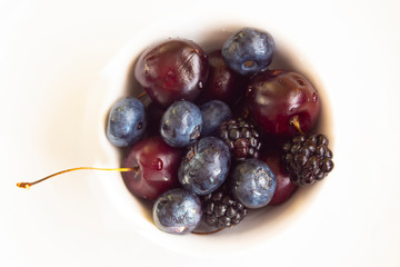 The gifts of nature. Cherries, blueberries, and blackberries. On a white background.