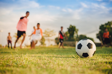 Action sport outdoors of kids having fun playing soccer football for exercise in community rural...