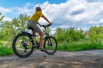 Teenager rides through the park on a bicycle