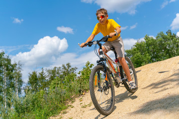 A teenager on a bike rides down a hill